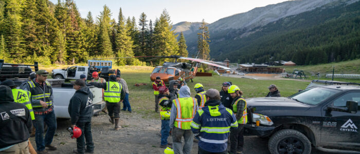 Group of workers coordinate in front of a helicopter.
