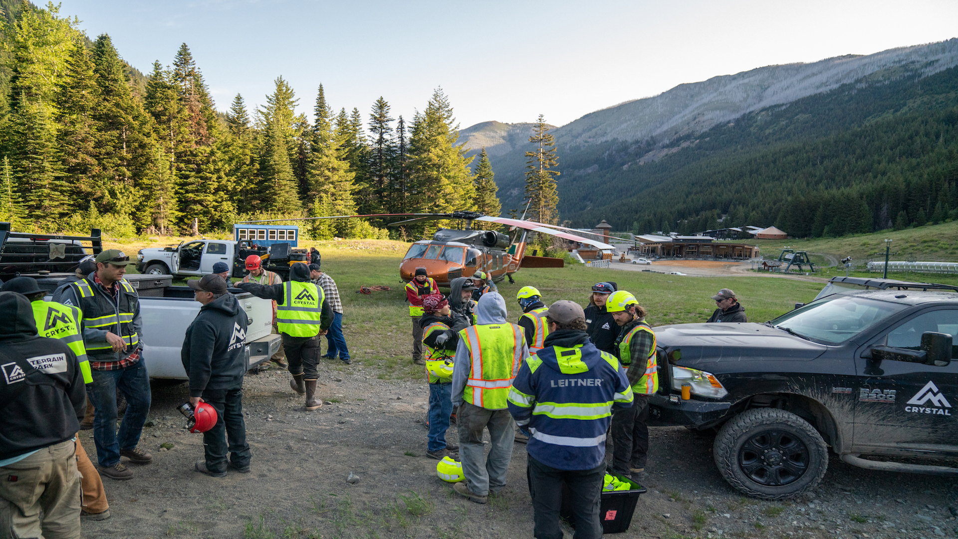 Group of workers coordinate in front of a helicopter.