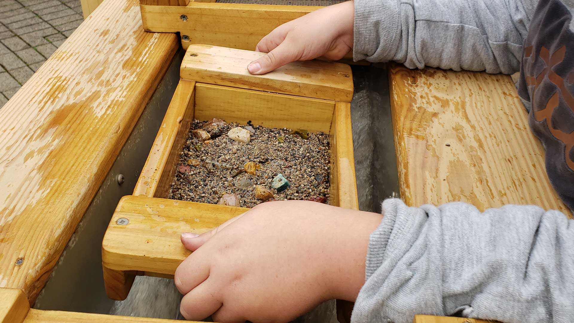 Children at mining sluice with gems