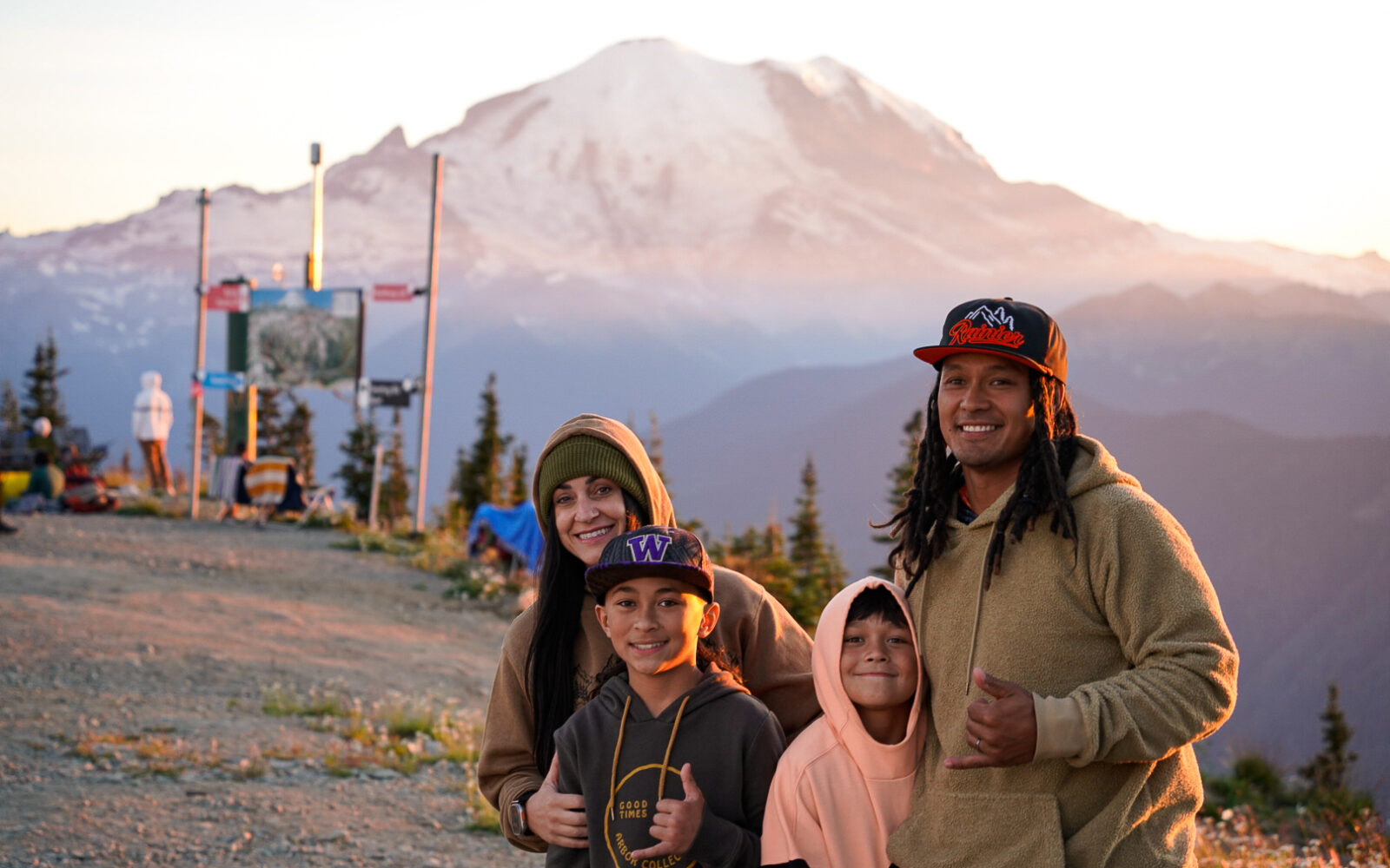 Family smiles in front of Mt. Rainier at sunset