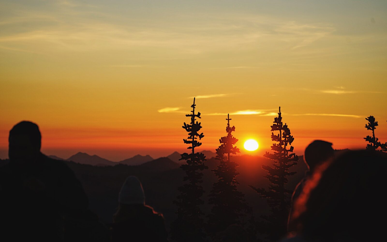 A small group of onlookers watches the sunset.