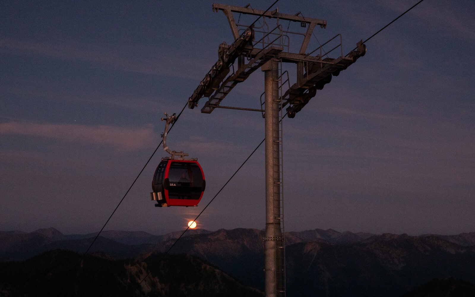 Scenic Gondola ascends to Summit Fest with a red moon in the background.
