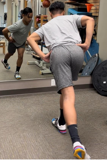 A person stretching in front of a mirror